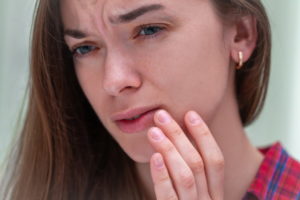 Frau mit gequältem Gesichtsausdruck - Herpes Menstrualis